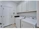 A functional laundry room features a washer, dryer, and ample cabinet storage at 970 Pembroke Point Way, Sun City Center, FL 33573