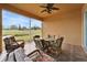 Enclosed patio with ceiling fan featuring comfortable seating and a view of the verdant golf course at 970 Pembroke Point Way, Sun City Center, FL 33573