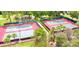 Aerial view of well-maintained tennis courts surrounded by lush greenery, perfect for active recreation at 970 Pembroke Point Way, Sun City Center, FL 33573