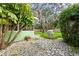 Secluded backyard with a stone patio, barbecue grill, and lush landscaping at 10350 54Th N Ave, St Petersburg, FL 33708