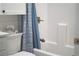 Bright bathroom featuring white cabinets and a tub with blue patterned shower curtain for a fresh and clean aesthetic at 10350 54Th N Ave, St Petersburg, FL 33708