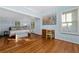 Light-filled bedroom featuring wood floors, soft blue walls, and an adjacent seating area with french doors at 10350 54Th N Ave, St Petersburg, FL 33708