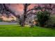 Inviting home with green exterior, mature trees, and expansive lawn at 10350 54Th N Ave, St Petersburg, FL 33708