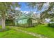 Charming two-story green home with well-maintained landscaping and a stone pathway at 10350 54Th N Ave, St Petersburg, FL 33708