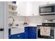 Bright kitchen with white and blue cabinets, farmhouse sink, and stainless steel microwave at 10350 54Th N Ave, St Petersburg, FL 33708