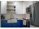 Stylish kitchen featuring white cabinets, blue lower cabinets, and stainless steel appliances at 10350 54Th N Ave, St Petersburg, FL 33708