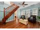 Cozy living room featuring hardwood floors, staircase, leather furniture, and light-filled windows at 10350 54Th N Ave, St Petersburg, FL 33708