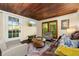 Cozy living room with hardwood ceilings, comfortable seating, and natural light from large windows at 10350 54Th N Ave, St Petersburg, FL 33708