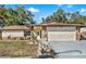 House exterior featuring stone accents, a two-car garage, and well-maintained landscaping at 1212 Markley Dr, Largo, FL 33770