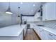 Open kitchen with white cabinets, large island, and hardwood floors at 13903 Natures Reserve Dr, Lithia, FL 33547