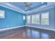 Main bedroom with hardwood floors, ceiling fan, and blue walls at 13903 Natures Reserve Dr, Lithia, FL 33547