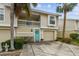 Two-story townhome with a teal door, two-car garage, and palm trees at 223 Sun Vista S Ct, Treasure Island, FL 33706