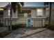 Two-story townhome with a teal door, two-car garage, and palm trees at 223 Sun Vista S Ct, Treasure Island, FL 33706