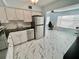 A Kitchen featuring stainless steel appliances, white cabinetry, black counter tops, and marble-patterned floors at 2311 Brisbane St # 65, Clearwater, FL 33763