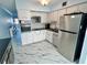 Well-lit kitchen featuring white cabinetry, stainless steel appliances, and modern marble-patterned flooring at 2311 Brisbane St # 65, Clearwater, FL 33763