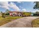 Front view of a ranch home with palm trees and a curved driveway at 2351 Leslee Lake N Dr, St Petersburg, FL 33713