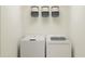 Bright laundry room with washer, dryer, and shelving at 5190 Meyer Bessie St, Zephyrhills, FL 33541