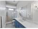 Modern bathroom with blue vanity, walk-in shower, and tiled floor at 5308 E Longboat Blvd, Tampa, FL 33615