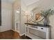 Bright entryway with wood floors, console table, and view of half bath at 535 52Nd N Ave, St Petersburg, FL 33703