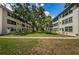 This exterior shows a well-maintained community lawn with mature trees and sidewalks between the buildings at 5880 38Th N Ave # 204, St Petersburg, FL 33710