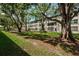 A shaded grassy lawn sits in front of this well-maintained building with mature shade trees at 5880 38Th N Ave # 204, St Petersburg, FL 33710