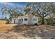 House exterior showcasing gray siding, black shutters and mature trees at 6923 Dartmouth N Ave, St Petersburg, FL 33710