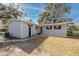 House exterior with gray siding, black shutters, and a spacious yard at 6923 Dartmouth N Ave, St Petersburg, FL 33710