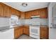 Bright kitchen with wood cabinets, white appliances, and tile flooring at 10515 118Th Ave, Largo, FL 33773