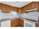 Bright kitchen with wood cabinets, white appliances, and tile flooring at 10515 118Th Ave, Largo, FL 33773