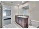 Bathroom features dual sinks, granite countertops, and view to the main bedroom at 11210 Kelly Green Ave, Wimauma, FL 33598