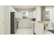 Modern white kitchen with stainless steel appliances and an L-shaped design at 12730 Crystal Jade Way, Parrish, FL 34219