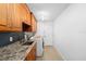 Practical laundry room with granite countertop, a utility sink, and storage cabinets above at 13001 Prestwick Dr, Riverview, FL 33579