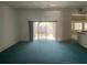 Spacious living room with teal carpet and sliding glass doors leading to the backyard at 13184 73Rd Ave, Seminole, FL 33776