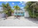 Gravel parking and patio with grill and tropical plants at 13405 Gulf Blvd, Madeira Beach, FL 33708