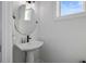 Small powder room with pedestal sink and round mirror at 1501 N Morgan St # 7, Tampa, FL 33602