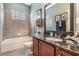 Bathroom with granite countertop, dark wood cabinets, and a shower/tub combo at 19116 Sweet Clover Ln, Tampa, FL 33647