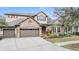 Two-story house with stone accents and a three-car garage at 19116 Sweet Clover Ln, Tampa, FL 33647