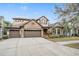 Two-story house with stone accents and a three-car garage at 19116 Sweet Clover Ln, Tampa, FL 33647