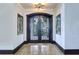 Elegant foyer with double doors, tile flooring, and decorative mirrors for a grand entrance at 200 Brightwaters Ne Blvd, St Petersburg, FL 33704