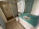 Bathroom with teal vanity, shower, and white toilet at 2226 Ridgemore Dr, Valrico, FL 33594