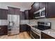 Kitchen with dark wood cabinets, granite counters, and stainless steel appliances at 2413 Baywood E Dr, Dunedin, FL 34698