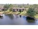 Scenic lakeside view with a charming home featuring a screened patio and lush greenery at 2679 Sabal Springs Cir # 102, Clearwater, FL 33761