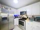 Clean kitchen featuring stainless steel refrigerator, cooking range, and well-lit microwave for efficient cooking at 2679 Sabal Springs Cir # 102, Clearwater, FL 33761