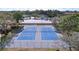 Aerial view of well-maintained community tennis courts surrounded by mature trees at 2679 Sabal Springs Cir # 102, Clearwater, FL 33761