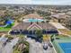 Aerial view of a community clubhouse, pool, sports courts, and meticulously landscaped grounds at 2813 Punta Palma Ct, Holiday, FL 34691