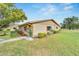 Tan single story home with red shutters, nicely landscaped lawn and walkway at 302 Canton Ct # 63, Sun City Center, FL 33573