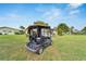 Black golf cart parked on the grass near a house at 302 Canton Ct # 63, Sun City Center, FL 33573