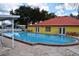 The clear community pool has an adjacent building with a red roof and chairs for residents to enjoy at 37642 Amigo Dr, Zephyrhills, FL 33541