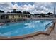 Enjoy the sparkling community swimming pool with ample seating and covered seating areas on a sunny day at 37642 Amigo Dr, Zephyrhills, FL 33541