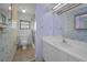 A cozy bathroom with tub and shower, decorated with colorful wallpaper and a mirror above the vanity at 523 Georgia Ave, Crystal Beach, FL 34681